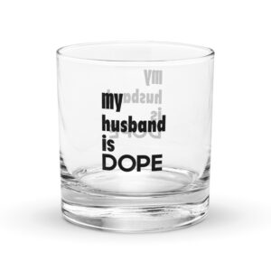 Close-up of a clear glass with bold black text reading 'my husband is dope' on its side.